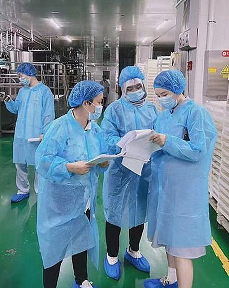 YUKANG QC team reviewing batch documentation in a cGMP cleanroom corridor